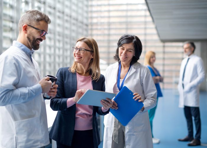 Group of doctors talking to pharmaceutical sales representative on conference.